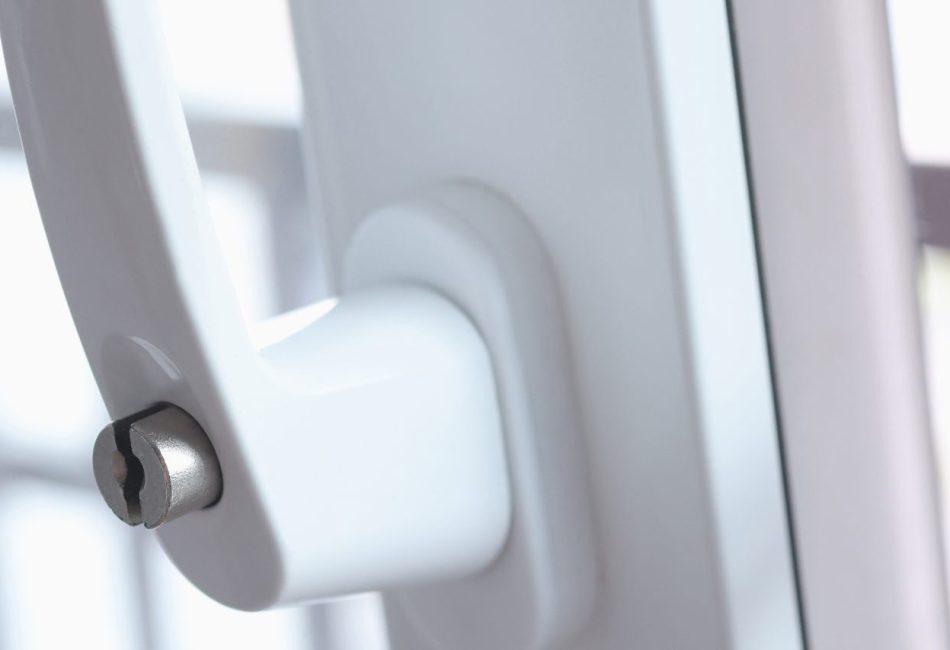 Balcony plastic door is on ventilation with raised handle and closed lock. Safety and options for protecting plastic windows from opening by children